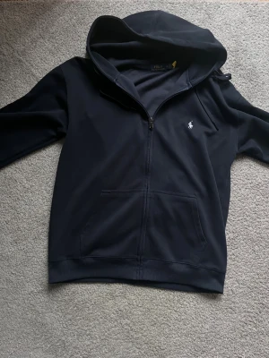 Ralph Lauren zip hoodie  - Tjenare. Säljer nu min Ralph lauren hoodie i storlek L då den inte kommer till användning längre. Den var för stor för mig därav säljer jag vidare den. Väldigt fint skick inga tecken på skador. Vid intresse hör gärna av er!