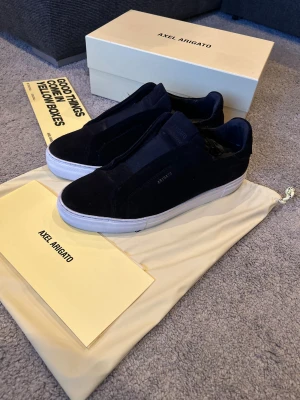 Axel Arigato - Snygga navy clean 360 laceless från Axel Arigato med minimalistisk design och vit platt sula. Väldigt bra skick som syns på bilder, storlek 45, box och allt ingår vid köp, pris går att diskutera vid enkel och snabb affär, de har slutat tillverkat denna modell, obs sulkräm har använts.