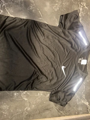 Svart Nike träningströja - Svart Nike T-shirt i storlek XS, kan även passa XXS. Helt ny och aldrig använd då jag köpte för liten under Black Friday. Passar bra att ha som vanlig T-shirt  under sommaren.