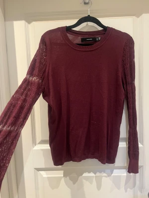 Vinröd stickad tröja Vero Moda M - Vinröd stickad tröja från Vero Moda i storlek M men skulle säga att den snarare passar S. Tröjan har långärmade spetsdetaljer med snyggt mönster på ärmarna och rund halsringning. Perfekt för dig som gillar en chill och stilren look med lite extra detaljer.