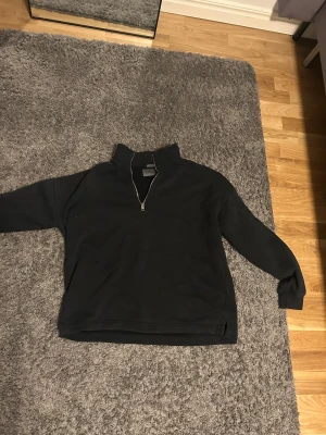 Svart oversized half zip från Soundless - Svart oversized tröja från Abercrombie & Fitch med halv dragkedja och hög krage. Mjuk fleece på insidan och ribbade muddar vid ärmslut. Perfekt torr look för höst och vinter, enkel att matcha med jeans eller sweatpants.
