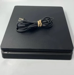 PlayStation 4 Slim - Sony PlayStation 4 Slim i fint skick. Konsolen är svart och levereras med strömkabel. Inga synliga repor eller skador på chassit. Perfekt för gaming och underhållning hemma.