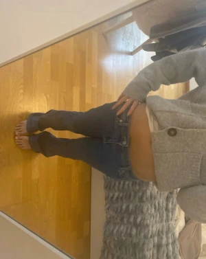 Blå bootcut jeans låg midja - Säljer ett par blå jeans med bootcut och låg midja. Jeansen har klassisk femficksdesign och är tillverkade i jeansmaterial. Färgen är mörkblå med lätt slitning vid bensluten för en cool, avslappnad vibe. Perfekt för dig som gillar retrostil och bekväma passformer. Storlek xs/32