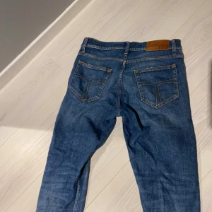 Tiger of Sweden Pistolero jeans blå - Snygga blå jeans från Tiger of Sweden i modellen Pistolero. Klassisk femficksdesign med raka ben och kontrastsömmar. Jeansen har normal passform och är tillverkade i slitstarkt denimtyg. Perfekt för dig som gillar stilrena och tidlösa jeans.