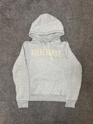 Abercrombie & Fitch Hoodie - Tja säljer nu en grå Abercrombie & Fitch Hoodie i storlek M men som passar mer som xs för endast 699kr! Pris är ej hugget i sten, hör av er i dm vid funderingar 🙌