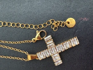 Guldigt halsband med glittrigt kors - Snyggt halsband i guldfärgad metall från EoY med ett stort kors som hänge, dekorerat med rektangulära, glittrande stenar. Kedjan har justerbar längd och en liten rund bricka med logga. Perfekt för dig som gillar statement-smycken och bling.