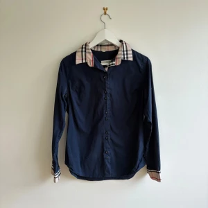 Burberry skjorta  - Burberry skjorta i storlek xs, den är i bra skick, längd: 71 cm axelbredd: 43 cm. Pris kan diskuteras, tveka inte på att höra av dig vid minsta fundering