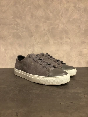 Axel Arigato Cap Toe sneakers - Hej! Säljer sneakers från Axel Arigato! Perfekt för dig som gillar stilrena och minimalistiska sneakers med premiumkänsla. I mycket bra skick utöver slitagen på högra tån! Dustbag följer även med. 