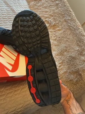 Nike Air Max DN svarta sneakers strl 46 - Nike Air Max DN sneakers i helsvart med diskreta grå detaljer och röd accent på yttersulan. Ovandel i mesh och syntet, med snörning och rund tå. Air Max-dämpning i sulan för extra komfort. Snygg, modern design med tydlig Air Max-logga på hälen. ordinare priset är på 1950kr plus frakten på nike.com med 85kr, jag säljer för 1500 helt nya för köpte 2 par i olika storlekar! endast testade hemma!