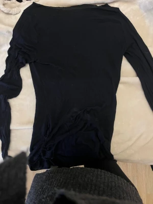 Intimissimi Svart långärmad topp i bomull - En enkel svart långärmad topp med rund hals. Tunn och mjuk i materialet, perfekt att styla med jeans eller kjol. Modellen är klassisk och passar dig som gillar en clean look. Materialet känns lätt och skönt mot huden.