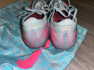 Nike Mercurial fotbollsskor turkos /rosa - Nike Mercurial fotbollsskor i turkos med rosa detaljer och snörning. Skorna har en smal, aerodynamisk form och är tillverkade i syntetmaterial med mönstrade sidor. Kommer med en matchande Nike-påse i grått och turkos. Perfekta för dig som vill sticka ut på planen.                    Köpt från unisport ny pris : 3000kr säljer pågrund av, köpt nya skor i mindre storlek.