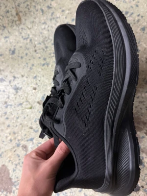 Svarta Active Lite sneakers - Säljer ett par svarta sneakers från Active Lite i storlek 39. Skorna har en stilren design med ventilerande meshmaterial, platt sula och snörning. Perfekta för dig som gillar sportig och clean look. Passar dig som vill ha bekväma skor till träning eller chill.