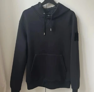Mackage Hoodie S - Säljer en svart hoodie från Mackage med stor logga på huvan och ett M på. Storlek S. Skick 8/10, köpt för 3800kr!