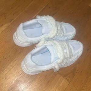 Nike P-6000 med fluffiga snören - Nike P-6000 i helvitt med chunky sula och unika fluffiga snören. Skorna har mesh och syntetdetaljer samt klassisk Nike-logga på sidan. Perfekta för dig som vill sticka ut med en cool och mysig detalj på fötterna. Kan diskutera pris!