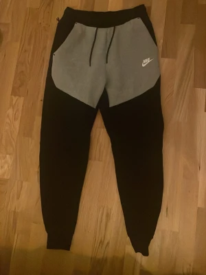 Nike tech byxor - Ett väldigt fint par Nike tech byxor, använt enstaka gånger, inga defekter, hör av er vid frågor