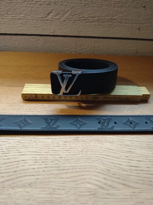 LV Bälte helt svart 110 cm silver - Snyggt bälte i svart med silver spänne 110 cm.