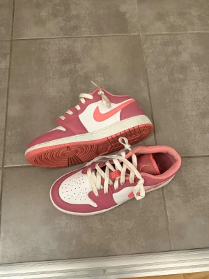 Nike Air Jordan 1 Low rosa/vit - Nike Air Jordan 1 Low sneakers i rosa och vitt med klassisk Air Jordan-logga på hälen. Använda några gånger. 
