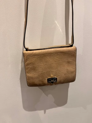 Beige axelväska från Diane von Furstenberg - Snygg beige axelväska från Diane von Furstenberg med croco-mönstrad yta i ÄKTA skinn. Väskan är köpt i NK.