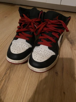 Nike Air Jordan 1 svart/vit/röd 37.5 - Nike Air Jordan 1 sneakers i svart, vit och röd. Lite slitna inne vid hälen, fler bilder kan skickas