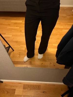 Svarta kostymbyxor från Lindex  - Ett par raka svarta kostymbyxor från Lindex i storlek 152 / 11-12 år. En enkel knap och dragkedja där fram på byxorna. Perfekta byxor att ha på sig till skolan eller bara ha hemma.