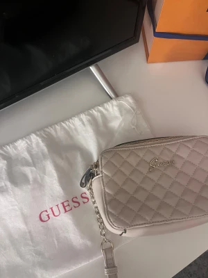 Beige axelväska från Guess - Väskan är endast använd en kväll & finns inga skador på den. 