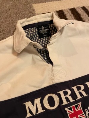 Morris pikétröja - Långärmad pikétröja från Morris i storlek Large. Med stiliga förstärkta armbågar i svart. Perfekt för dig som gillar klassisk stil. Hör av dig vid minsta fundering! :)