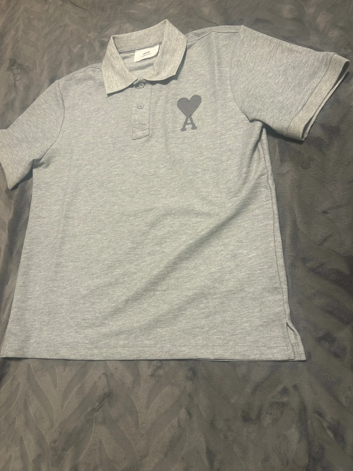 Grå polo från Ami med hjärtdetalj