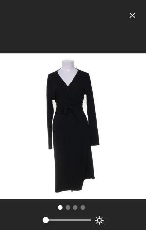 Svart omlottklänning från NLY Trend - Svart långklänning från NLY Trend med omlott-design och v-ringad hals. Klänningen har långa ärmar och knyt i midjan för en snygg siluett. Tillverkad i mjukt material med 64% polyester, 33% viskos och 3% elastan. Perfekt för dig som gillar stilrena och enkla plagg. Köp på Sellpy men då den inte kommer till andvädnig så säljer jag den pris går alltid att diskutera 