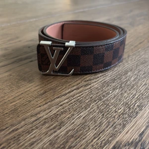 Brunt och silver bälte  - Brunt och silvrigt L&V bälte. 105 cm