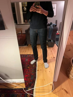 Nudie Jeans - Snygga mörkblå jeans från Nudie Jeans med klassisk femficksdesign och kontrastsömmar. Modellen har rak passform och normal midja, tillverkade i slitstarkt jeanstyg. Perfekta för dig som gillar stilrena och tidlösa jeans med coola detaljer. Modell dude dan 