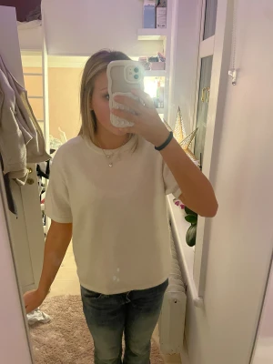 Vit stickad topp från Gina Tricot - Säljer en vit stickad topp från Gina Tricot i storlek 170. Toppen har rund hals, korta ärmar och är i en mjuk stickad kvalitet. Perfekt för dig som gillar enkel och clean stil. Passar till jeans eller kjol och är superenkel att matcha med smycken.