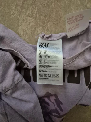 Tröja - Ljuslila croppad långärmad tröja från H&M med tryck 'Sierra Nevada Mountains' och bergmotiv i lila toner. Rund hals med liten slits framtill, mjukt bomullsmaterial och avslappnad passform. Perfekt för dig som gillar coola prints och chill vibe.