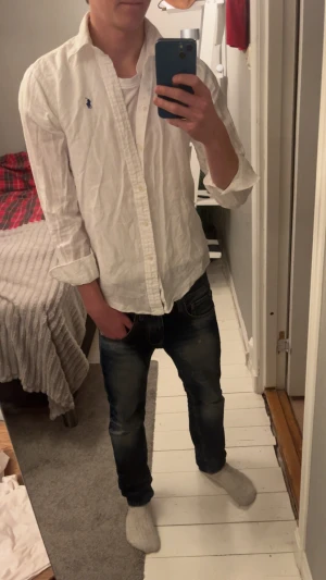 Vit skjorta från Polo Ralph Lauren XS - Vit skjorta från Polo Ralph Lauren i klassisk modell med blå broderad logga på bröstet. Skjortan har lång ärm, knappar framtill och krage. Tillverkad i linne perfekt för sommaren eller som ett plagg för lager på lager😁hör av er vid funderingar!🤗🤗