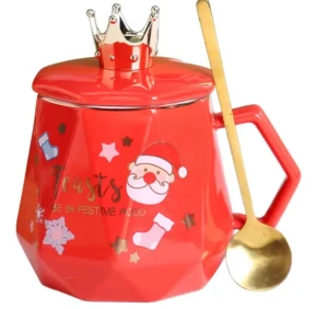 Julmugg med lock och sked, presentset - Festlig julmugg i röd keramik med lock i form av en krona och medföljande guldfärgad sked. Dekorerad med tomtemotiv och text. Levereras i presentförpackning – perfekt som julklapp! Muggen ser oanvänd ut och är i nyskick.
