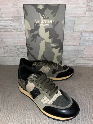 Valentino Garavani Rockrunner sneakers - Snygga Valentino Garavani sneakers med ett coolt camouflage-mönster. Skorna har snörning och en kombination av gröna och svarta detaljer. Perfekta för en trendig look. Passar även bra på storlek 44