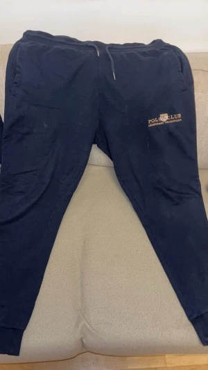 Mörkblå hoodie från Vinson Polo Club - Snygg mörkblå hoodie från Vinson Polo Club med broderad logga och text på bröstet. Tröjan har huva med snörning, magficka och långa ärmar. Perfekt för chill dagar och har en klassisk, sportig look. Man får med hela setet