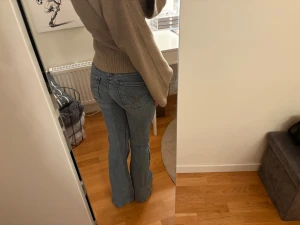 Lågmidjade bootcut jeans i ljusblå denim - Snygga lågmidjade jeans i ljusblå denim med bootcut-ben. Jeansen har klassiska fem fickor och dekorativa sömmar på bakfickorna. Perfekta för dig som gillar en retro vibe och vill ha ett par jeans som sitter tajt upptill och släpper vid benen.