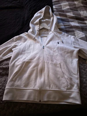 Vit hoodie från Polo Ralph Lauren - Säljer denna feta Ralph Lauren zip hoddien i storlek M Sparsamt använd  Enda defekt är en liten fläck på vänster ficka, går säkert å tvätta bort med något medel Fler bilder kan ordnas