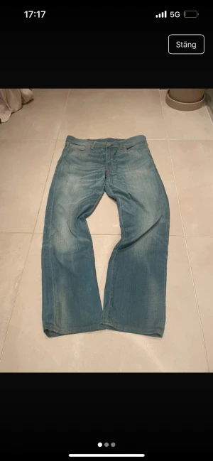 Levi's 504 ljusblå jeans W31 L34 - Säljer ett par klassiska Levi's 504 jeans i ljusblå tvätt. Jeansen har rak passform, fem fickor och snygga slitningar för en avslappnad look. Perfekta för dig som gillar en tidlös stil med lite bredare ben. Materialet är 100% bomull.