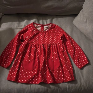 Julklänning - Supersöt prickig julklänning med hjärtan som fickor fram. Polarn o pyret. Som ny. Rök-/djurfritt hem.