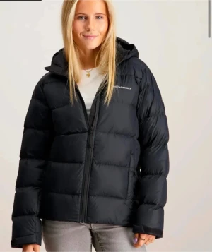 Peak Performance - W Frost Down Jacket - Säljer en svart pufferjacka från Peak Performance med huva och dragkedja framtill. Jackan har en clean look med diskret logga på bröstet och breda, quiltade paneler. Perfekt för kalla dagar och riktigt snygg.                            Peak performance  W Frost Down Jacket             Stl:M    Färg: Svart Art nr:  7333269686412 Nypris: 2999 kr. Inköpt: 14 dec 2024             Mycket bra skick 