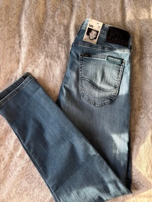 Lee Luke - Ett par sprillans nya Lee luke slim tapered jeans i en schysst blå färg, brallorna har aldrig kommit till användning pga för långa och har inte haft möjligheten till att lämna tillbaks dom. Bara hojta till om du undrar över något🙌🏼