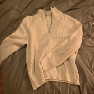 Vit stickad half zip tröja H&M XL - Säljer en vit stickad tröja från H&M i storlek XL. Tröjan har en ribbad struktur, hög krage och half zip-dragkedja framtill. Regular fit och långa ärmar gör den både chill och snygg. Perfekt för kalla dagar när du vill vara både bekväm och stilren.