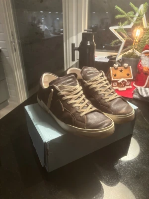 Bruna Philippe Model  - Snygga bruna sneakers från Philippe Model med beige snörning och vit sula. Storlek 44. Välanvända! Kan gå ner i pris vid en snabb affär! Tveka inte på frågor!!