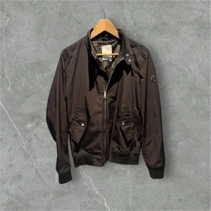 J Lindeberg vind/regnjacka - Svart vind/regnjacka från j Lindeberg. Riktigt snygg med metallloggan på ärmen. Väldigt bra skick, jätte bekväm och skön jacka. Hör av er vid frågor!