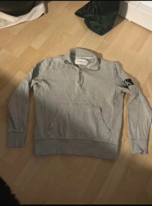 Calvin Klein Jeans Quarter-Zip Tröja XS - Tröjan är använd endast ett fåtal gånger och är i nästan nyskick utan några defekter. Den har bra passform i storlek XS och är tillverkad i ett mjukt och skönt material. Tröjan har en halv dragkedja, känguruficka framtill och den klassiska CK Jeans-patchen på ärmen. Skriv vid frågor (ej fast pris)
