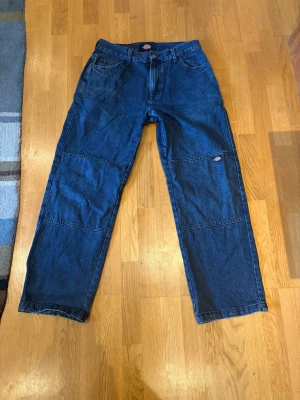 Blå Dickies jeans med double knee i baggy passform - Säljer ett par blåa double knee jeans från Dickies med raka ben och double knee sydda. Perfekt för dig som gillar streetwear/workwear. Nypris var runt 1200kr. 