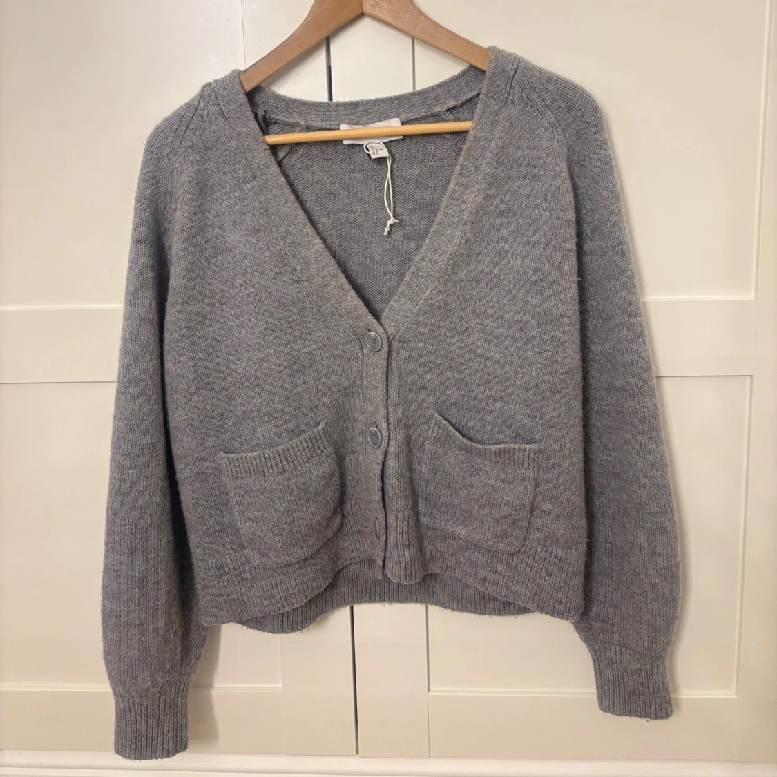 Stickad kofta med knappar och fickor