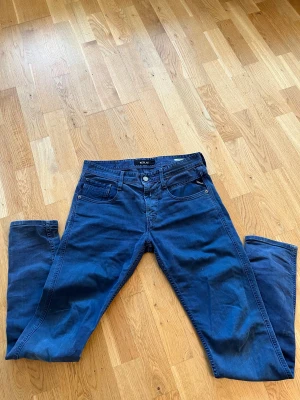 Blå Replay Anbass jeans, 30/32 - Snygga blå Replay Anbass jeans med klassisk femficksdesign och raka ben. Jeansen har normal passform och är tillverkade i mjukt bomullsmaterial med en stilren look. Perfekt för dig som gillar en enkel och tidlös stil. Pris kan diskuteras vid snabb affär.