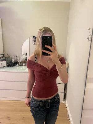 Vinröd topp med twistad front - Supersnygg vinröd topp från Lindex med twistad detalj framtill. Toppen har breda axelband och en djup v-ringning både fram och bak. Materialet är mjukt och stretchigt, perfekt för att skapa en cool och trendig look. Storleken är XS men den borde även passa som en S. Använd 1-2 gånger. 